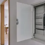 Geöffneter Zählerkasten im Wohnungsflur mit digitalem Stromzähler und Sicherungsautomaten